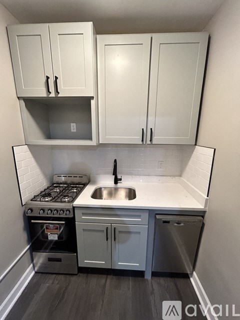 A kitchen with white cabinets and a stove top oven.