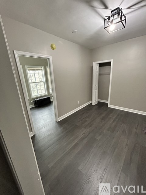 A room with wooden flooring and a window.