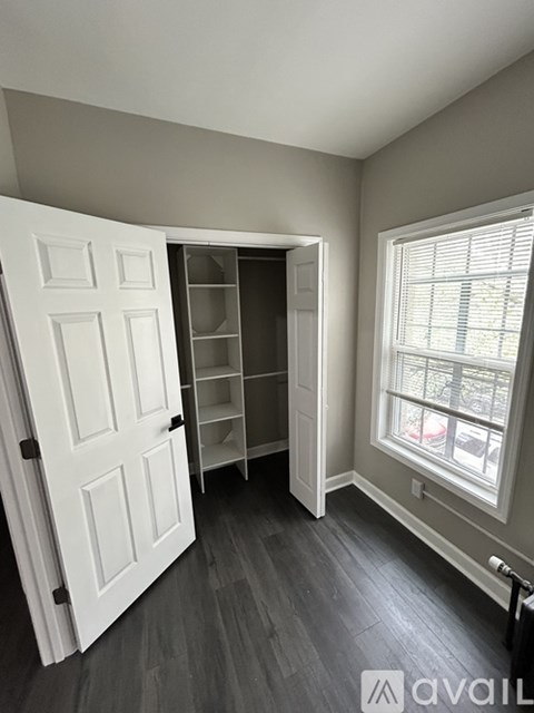 A room with a white door and a window with blinds.