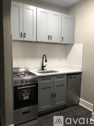 A kitchen with white cabinets and a stove top oven.