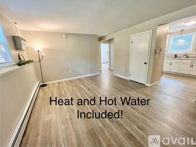 A room with a sign that says "Heat and Hot Water Included!" is shown.