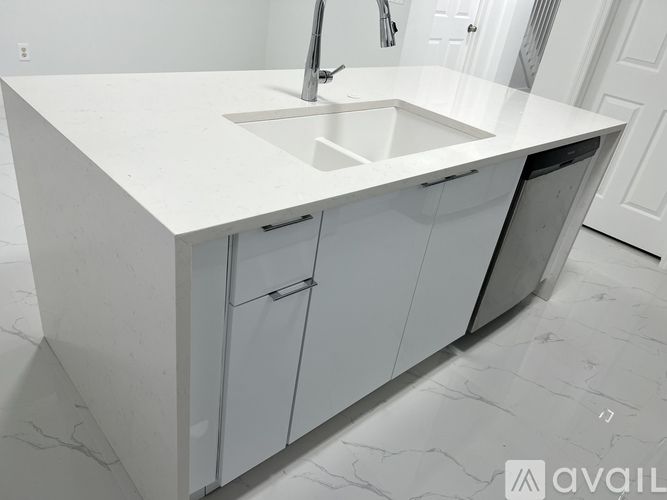 A white kitchen with a sink and cabinets.