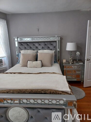 A bed with a grey headboard and white bedding is in the image.