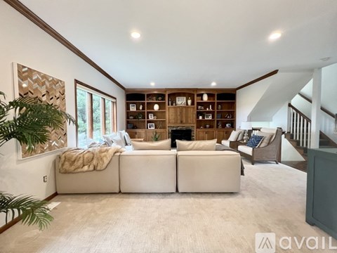 A living room with a large sectional sofa and a fireplace.