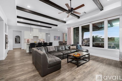 A living room with a large couch and a ceiling fan.