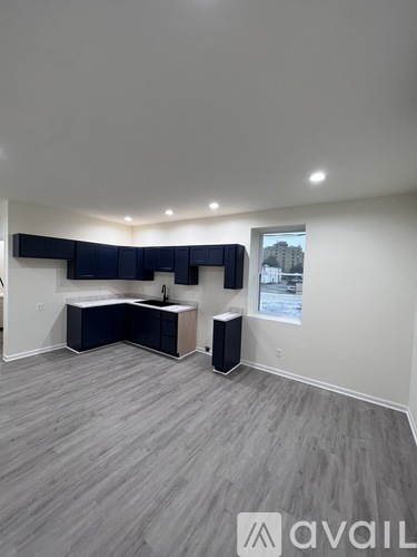 A room with a grey floor and a window showing a cityscape.