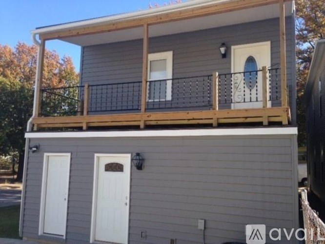 A two-story house with a balcony on the upper level.