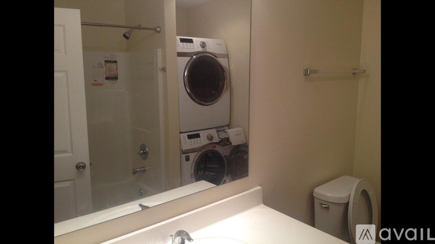 A washing machine is reflected in a bathroom mirror.