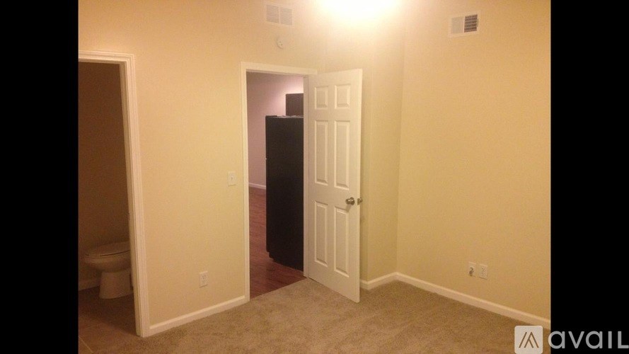 A room with a door and a toilet in it.