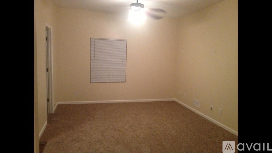A room with a carpeted floor and a whiteboard on the wall.