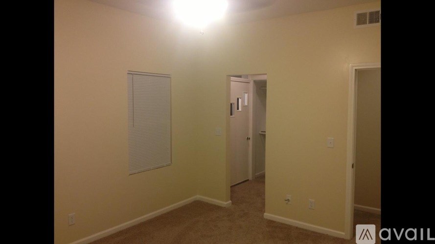 A room with a light on and a door in the background.