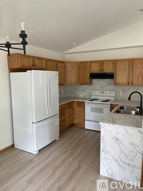 A kitchen with a white fridge and wooden cabinets.