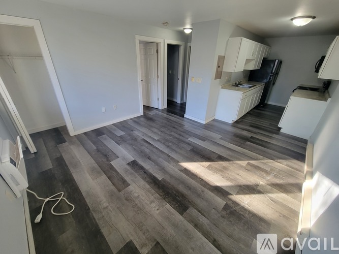 A room with wooden flooring and white walls.