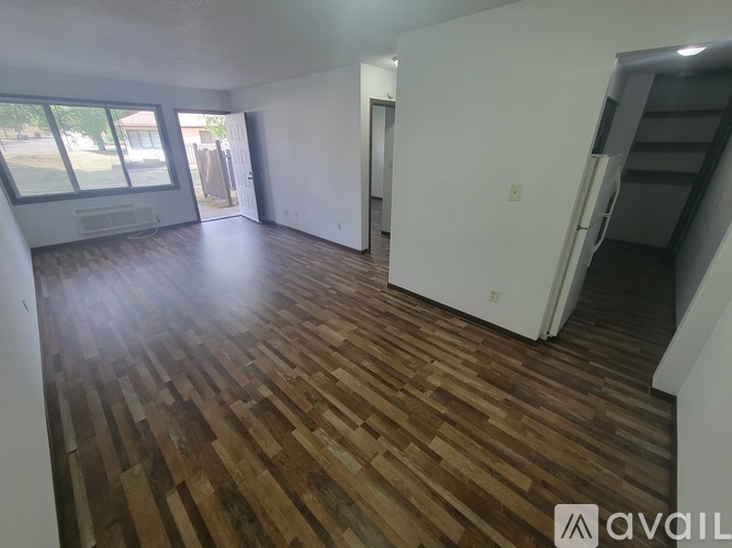 A room with wooden flooring and a staircase.