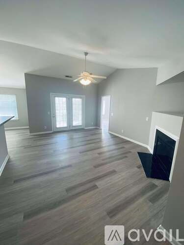 A living room with a fireplace and wood flooring.