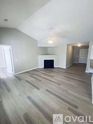 A room with wooden floors and a window with blinds.