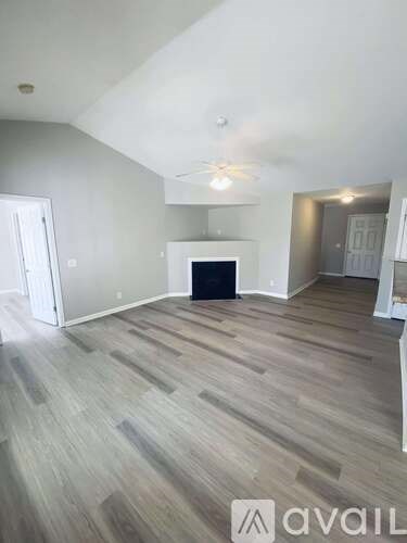 A room with wooden floors and a window with blinds.