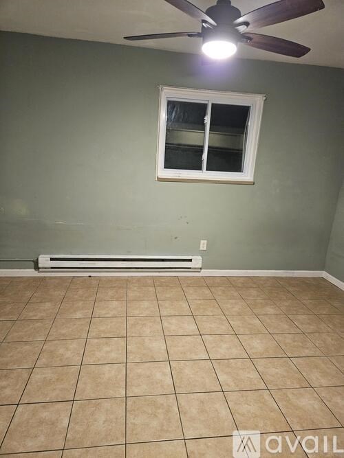 A room with a ceiling fan and a window.