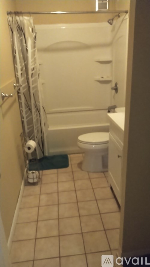 A bathroom with a toilet, a tub, and a towel rack.