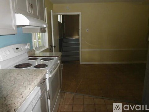 A kitchen with a white stove top oven and a white range hood.