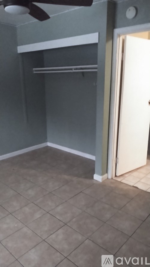 A room with a ceiling fan and a door.