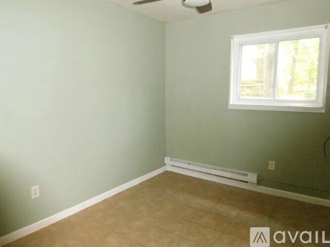 A room with a window and a tiled floor.