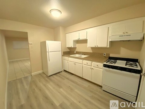 A kitchen with white appliances and cabinets.