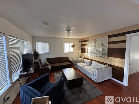 A living room with a blue couch and a white sofa.