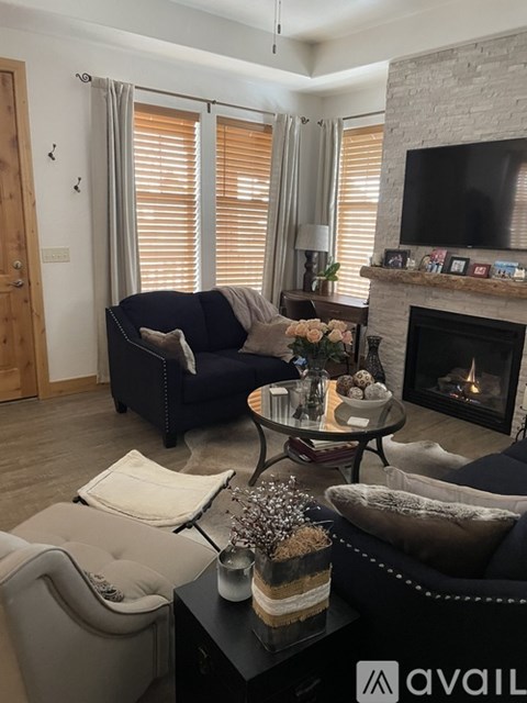 A living room with a fireplace and a television on the wall.