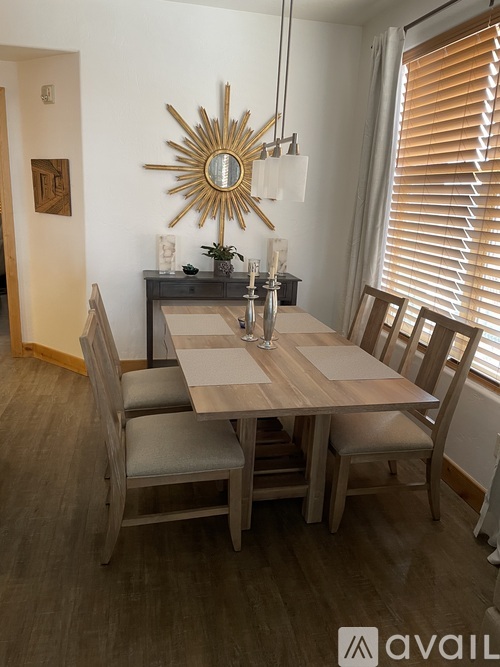 A dining room with a wooden table and chairs.