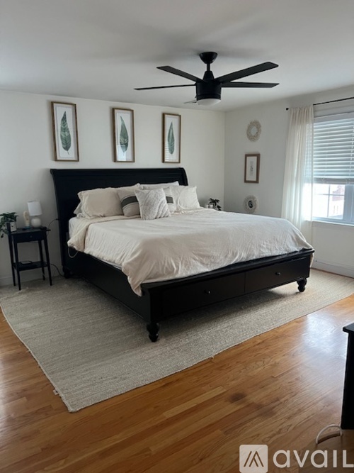 A bedroom with a large bed and a ceiling fan.