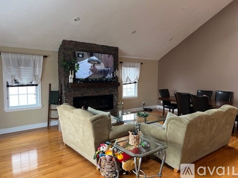 A living room with a fireplace and a television on the wall.
