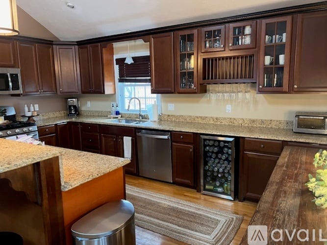 A kitchen with brown cabinets and a granite countertop.