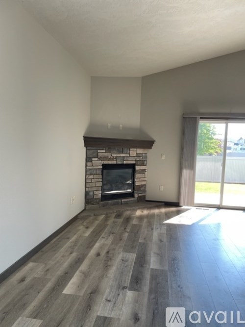 A living room with a fireplace and wood flooring.