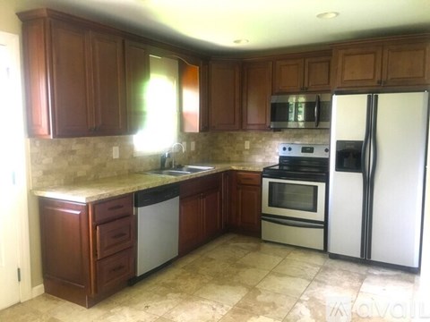 A kitchen with brown cabinets and a white refrigerator.