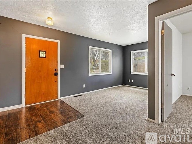A room with a brown door and grey walls.