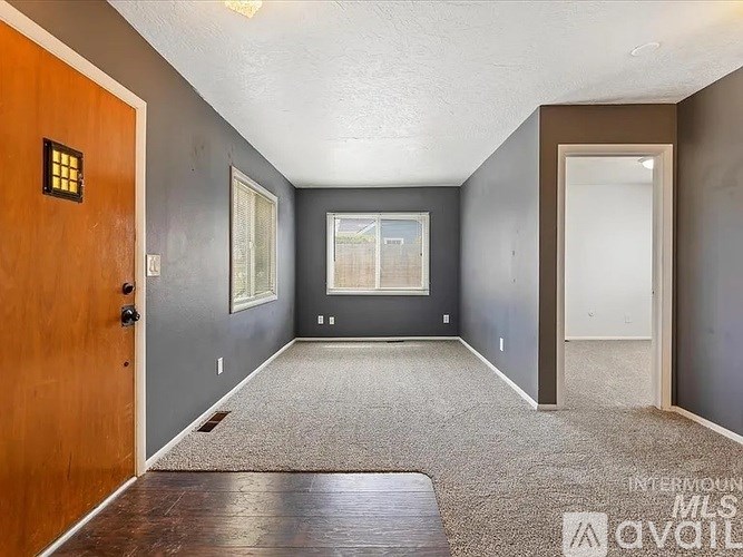 A room with a brown door and grey walls.