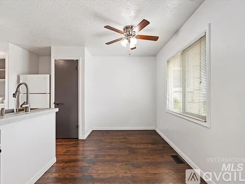 A kitchen with white cabinets and a wooden floor.