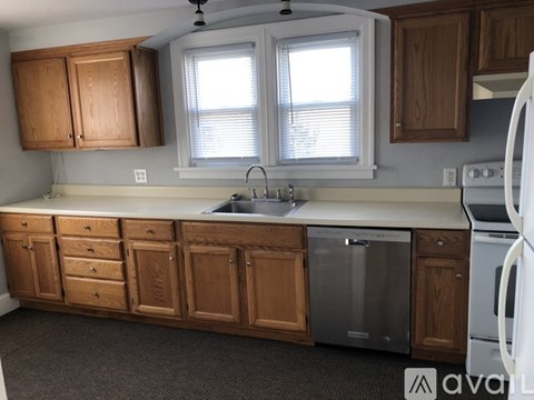 A kitchen with wooden cabinets and a white fridge.