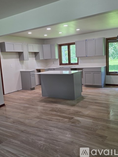 A kitchen with wooden floors and white cabinets is available for rent.