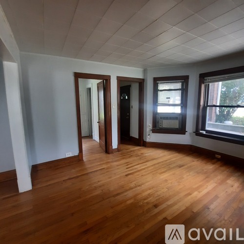 A room with wooden floors and a window on the right side.