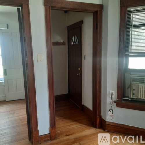 A room with a wooden floor and a brown door.