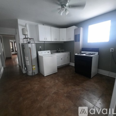 A kitchen with brown flooring and white appliances.