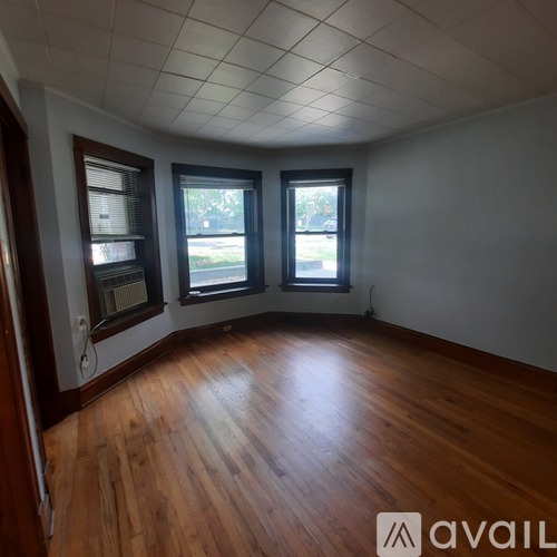 A room with wooden floors and two windows.