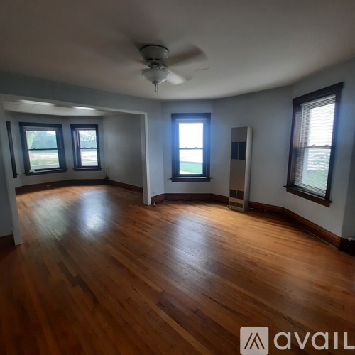 A room with wooden floors and a ceiling fan.