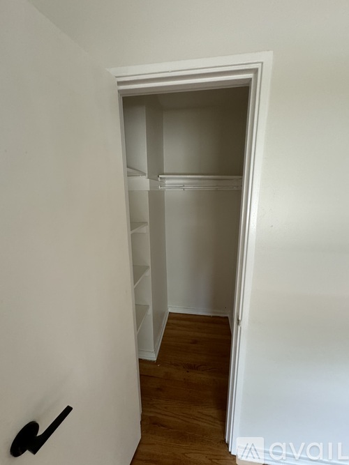 A white doorway leads to a room with a wooden floor.