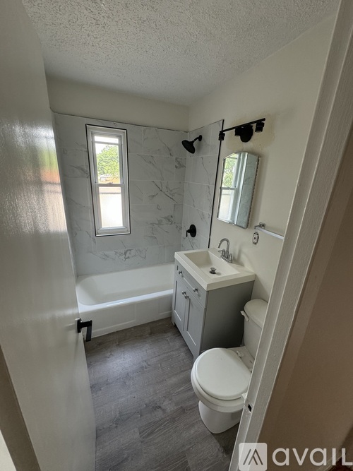 A bathroom with a toilet, sink, and bathtub.