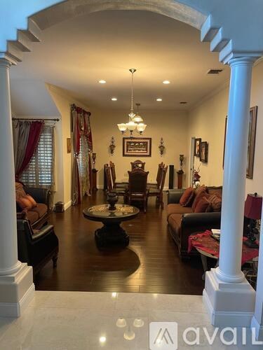 A living room with a large table and chairs.