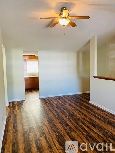 A room with wooden floors and a ceiling fan.