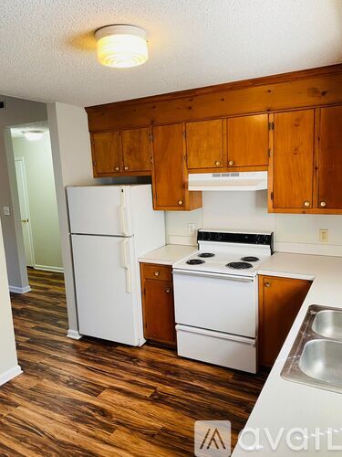 A kitchen with wooden cabinets and white appliances.